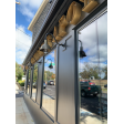 (3) 10” Wilcox, 997-Natural Raw Brass, G15 Gooseneck Arm in 100-Black, Cast Guard in 100-Black with Clear Glass | Photo Courtesy of Green Line Apothecary and Lineage Corporation